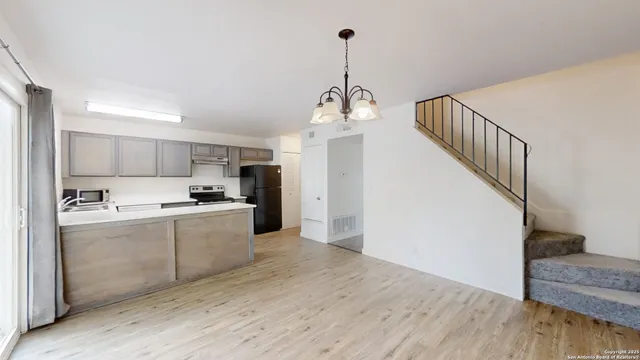 a kitchen with stainless steel appliances kitchen island a sink cabinets and wooden floor
