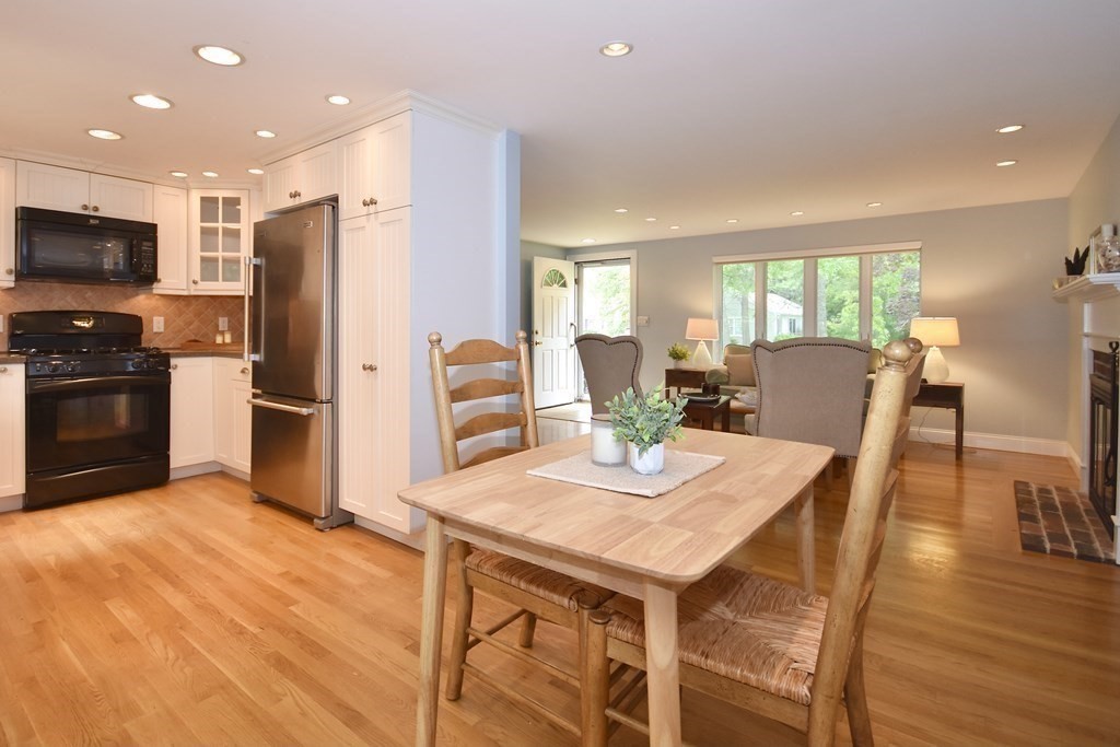 186 Sheaffer Road Barnstable, MA 02632 - Photo 7 of 29 a kitchen with stainless steel appliances granite countertop a stove a refrigerator a kitchen island and chairs with wooden floor