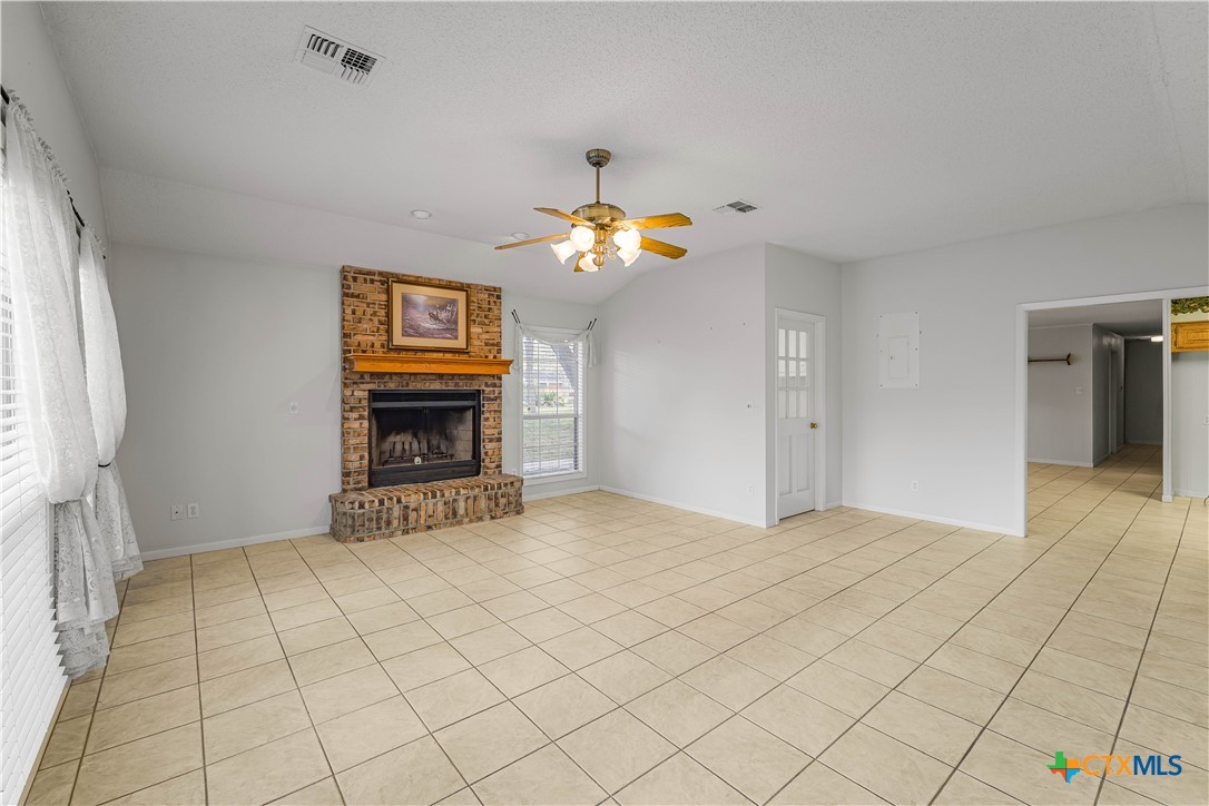 406 Blyth Road Victoria, TX 77904 - Photo 13 of 32 a view of an empty room with chandelier fan and fireplace