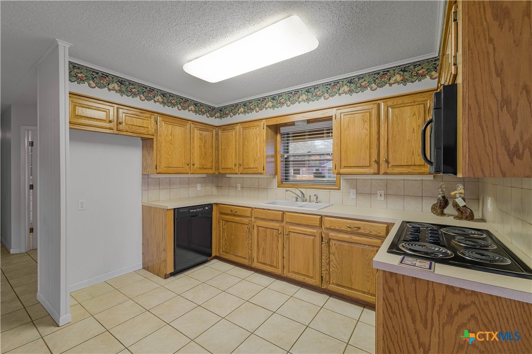 406 Blyth Road Victoria, TX 77904 - Photo 19 of 32 a kitchen with a stove a sink and a refrigerator