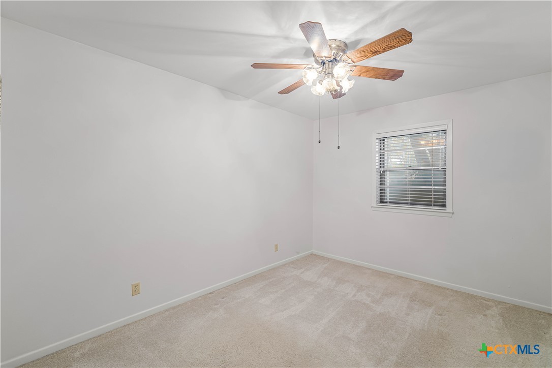 406 Blyth Road Victoria, TX 77904 - Photo 21 of 32 an empty room with a window and a ceiling fan