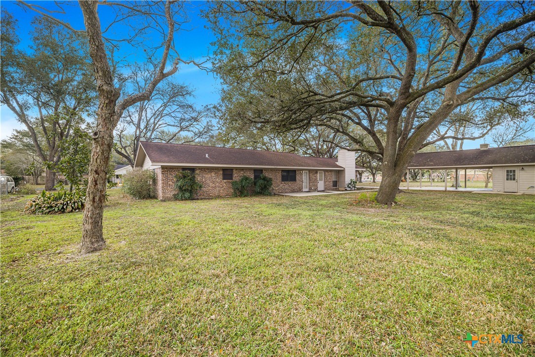 406 Blyth Road Victoria, TX 77904 - Photo 7 of 32 a front view of a house with a garden and trees