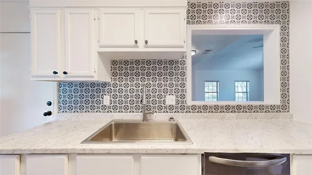 a en suite bathroom with a granite countertop sink and a mirror