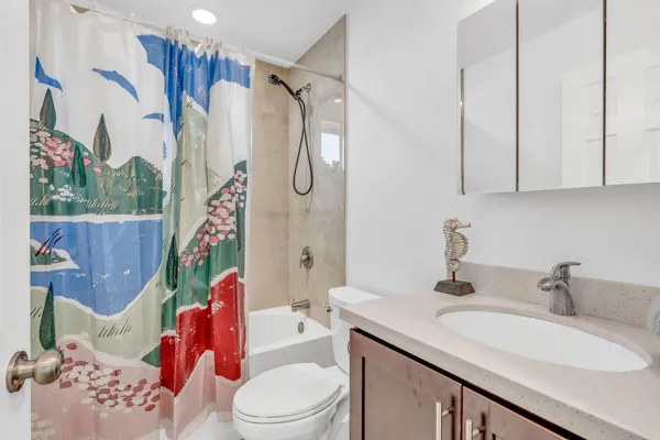 a bathroom with a sink vanity mirror and toilet