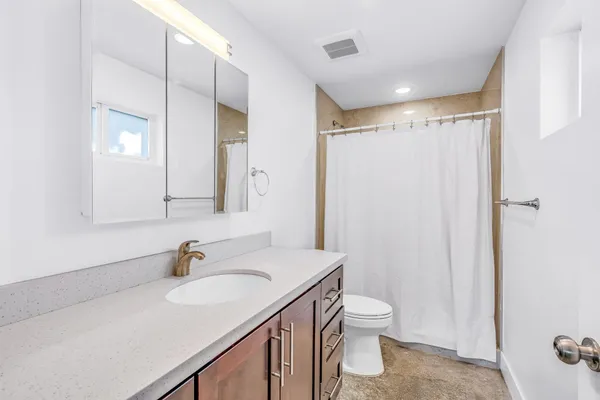 a bathroom with a sink toilet double vanity and shower