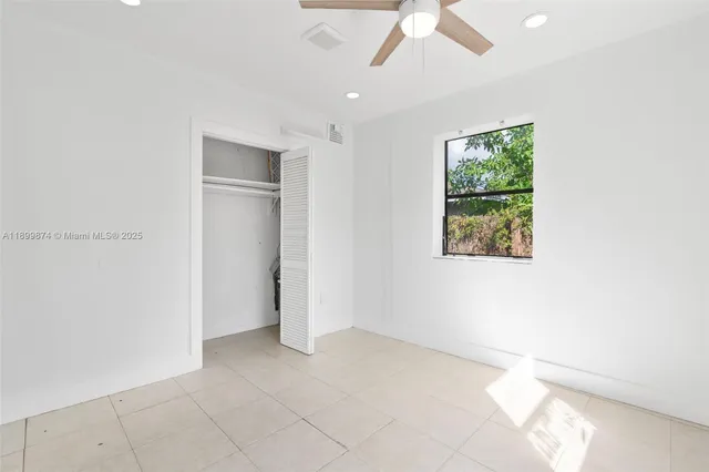 an empty room with windows and closet
