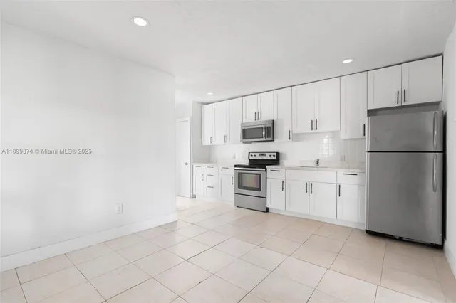 a kitchen with white cabinets and white appliances