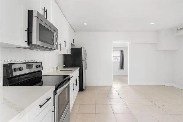 a kitchen with stainless steel appliances a stove microwave and sink