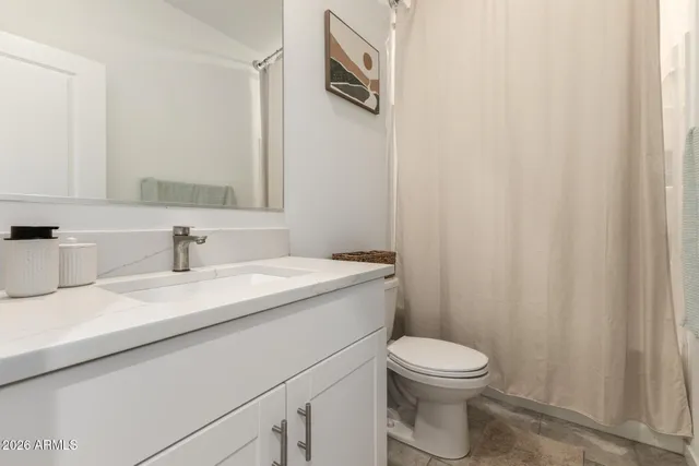 a bathroom with a sink a toilet and a mirror