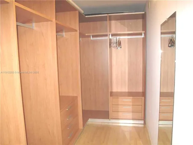 a view of a small space with wooden floor and a window