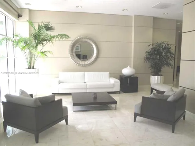 a living room with couches a mirror and a potted plant