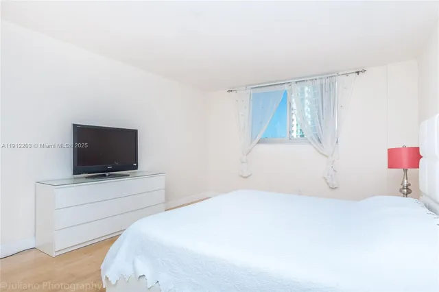 a bedroom with a bed and a flat screen tv