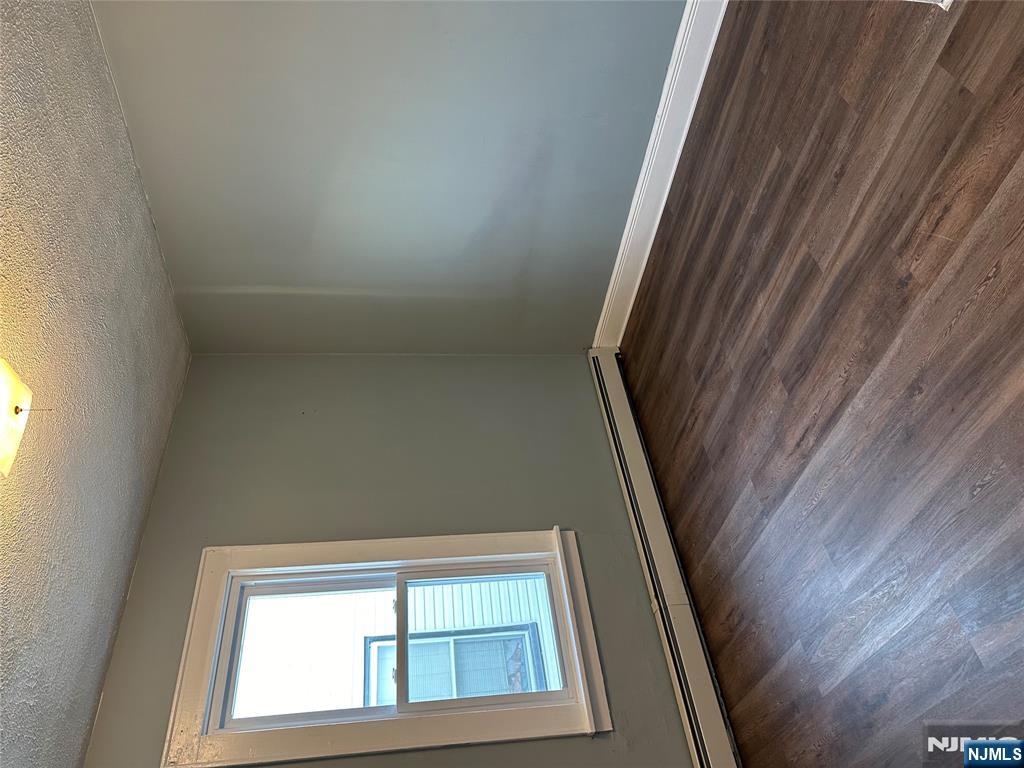 122-124 Buffalo Avenue, Unit 4 Paterson, NJ 07503 - Photo 11 of 14 a view of an empty room with wooden floor and a window