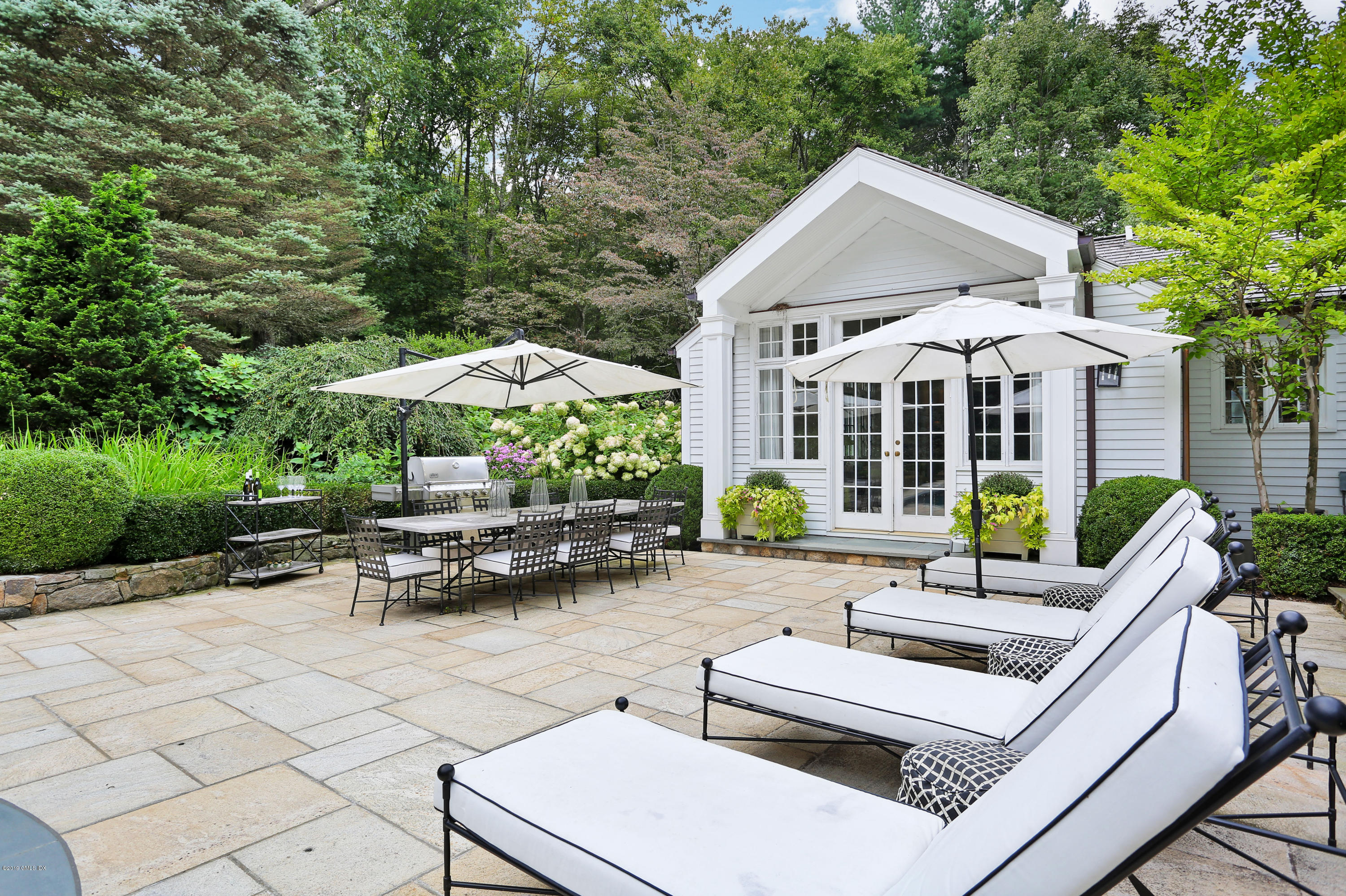 418 Riversville Road Greenwich, CT 06831 - Photo 33 of 38 a view of a patio with chairs and tables with a umbrella