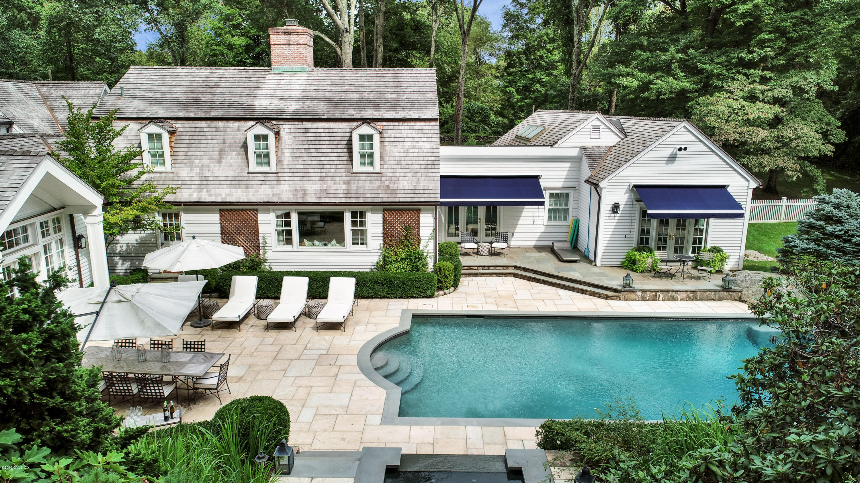 418 Riversville Road Greenwich, CT 06831 - Photo 34 of 38 a view of a white house with large windows and a table and chairs