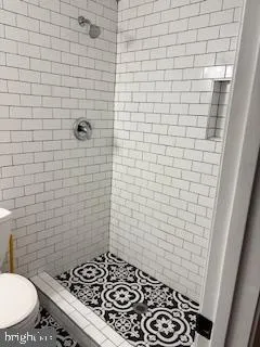 a bathroom with a toilet and a shower