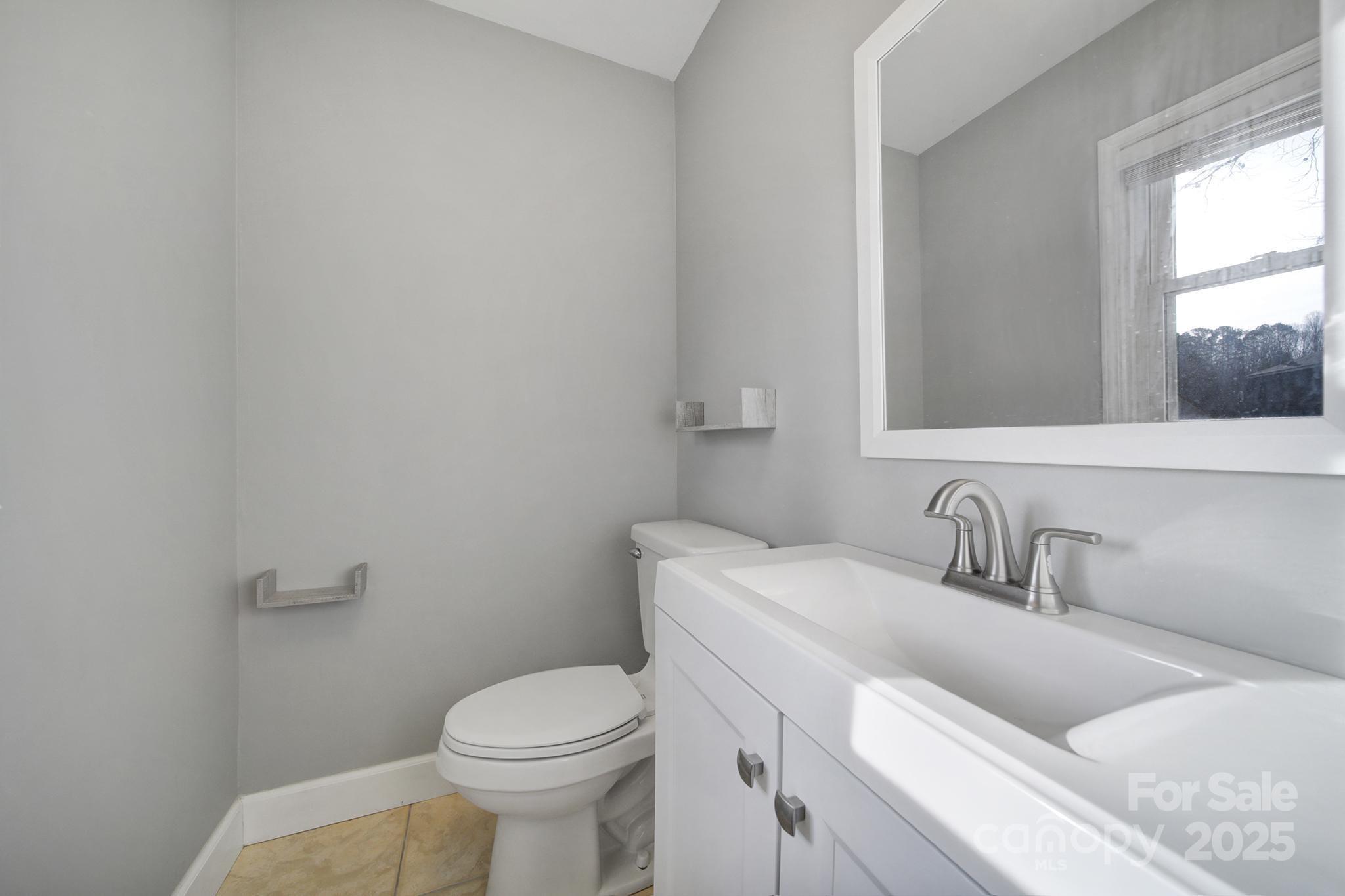 1019 Palmyra Drive Tega Cay, SC 29708 - Photo 26 of 42 a bathroom with a toilet sink and mirror