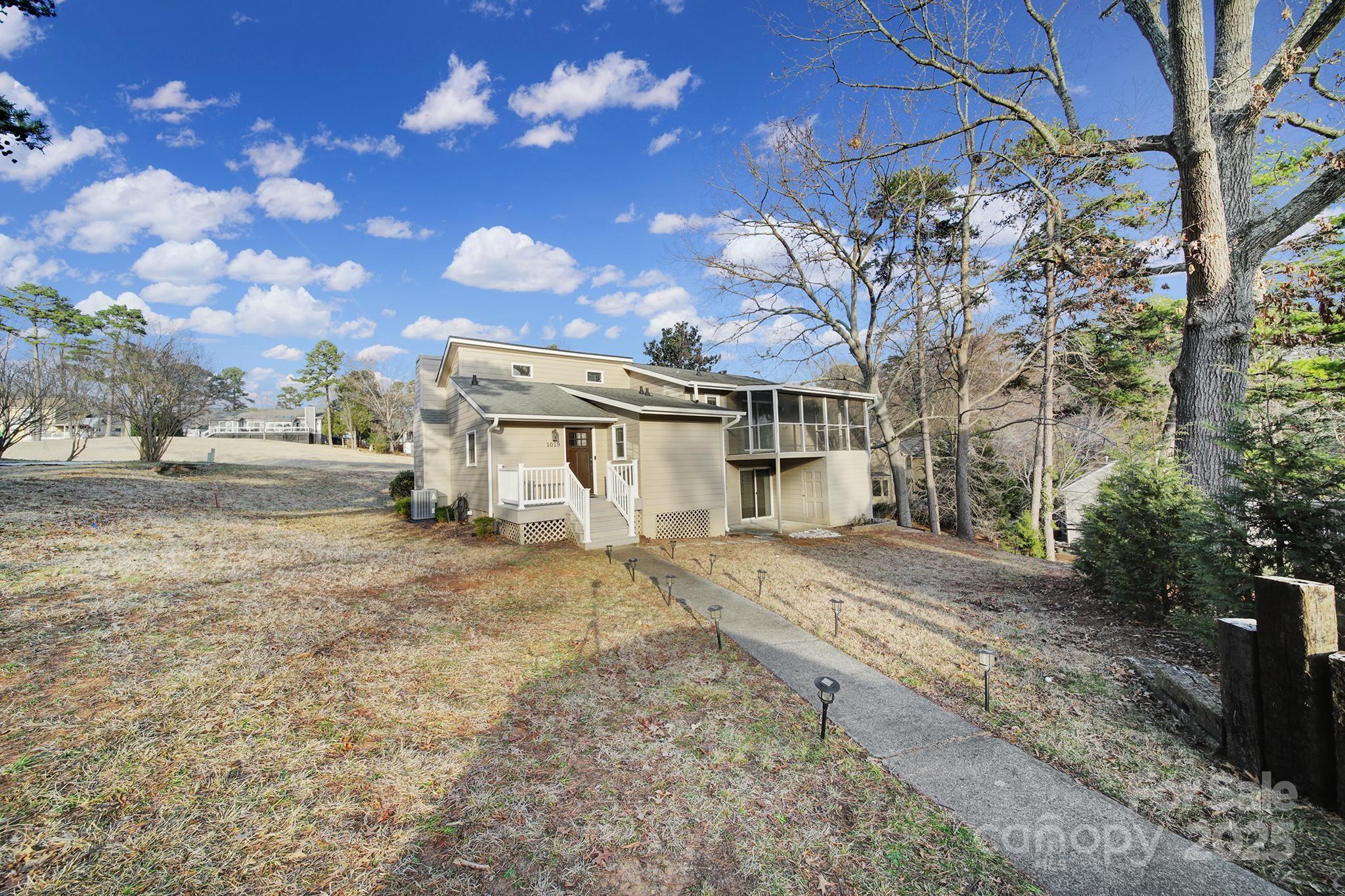 1019 Palmyra Drive Tega Cay, SC 29708 - Photo 33 of 42 a view of a large white house with a yard covered with snow in the background