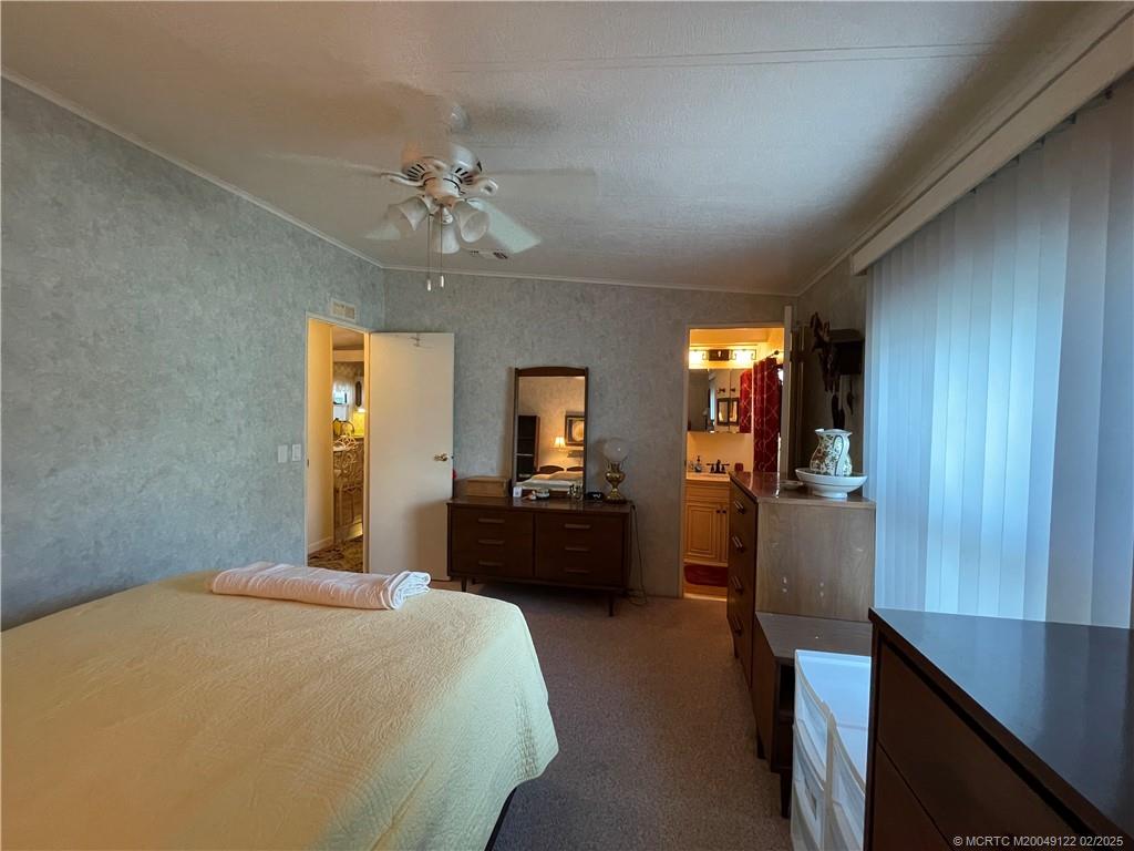 14663 Southwest Rake Drive Indiantown, FL 34956 - Photo 23 of 36 a bedroom with a bed and a chandelier