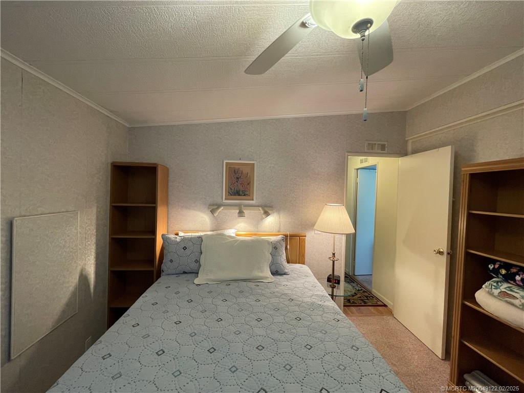 14663 Southwest Rake Drive Indiantown, FL 34956 - Photo 26 of 36 a bedroom with a bed and a lamp