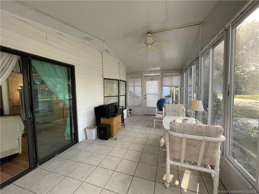 14663 Southwest Rake Drive Indiantown, FL 34956 - Photo 6 of 36 a living room with couches a fireplace and a large window with outer view