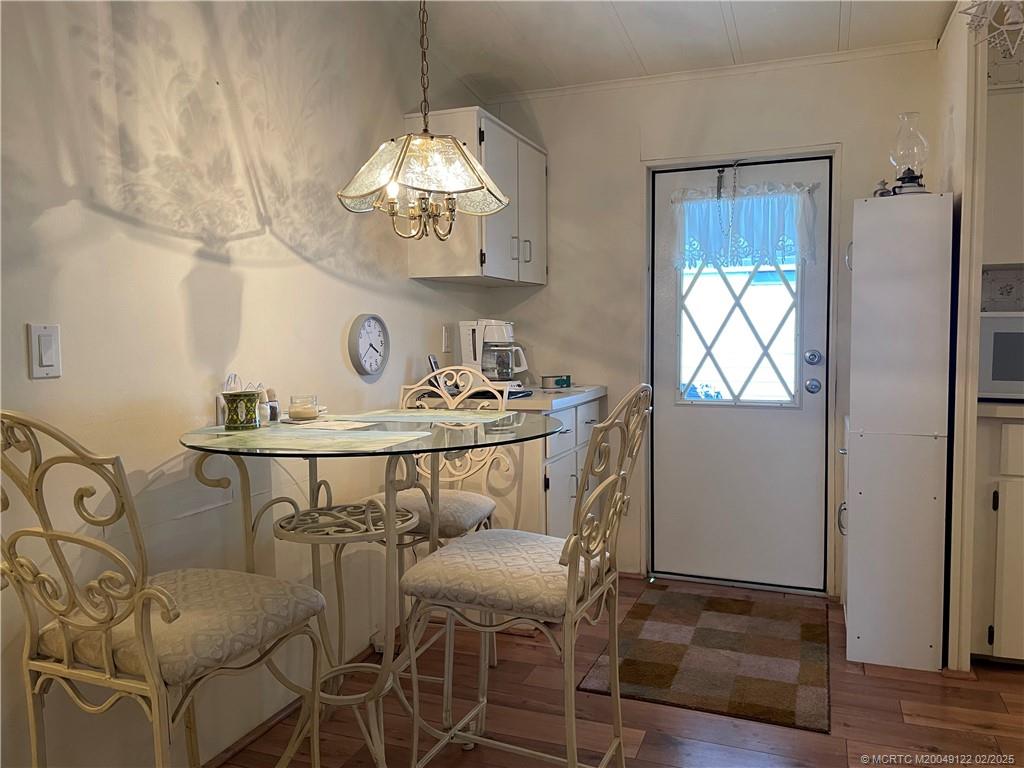14663 Southwest Rake Drive Indiantown, FL 34956 - Photo 8 of 36 a view of a dining room with furniture a chandelier and wooden floor