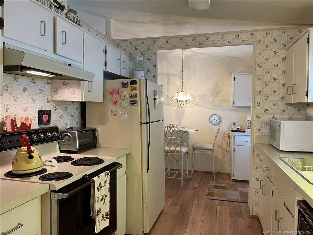 14663 Southwest Rake Drive Indiantown, FL 34956 - Photo 10 of 36 a kitchen with a sink stove and refrigerator