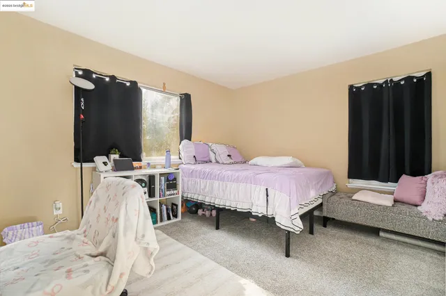 a bedroom with a bed flat screen tv and window