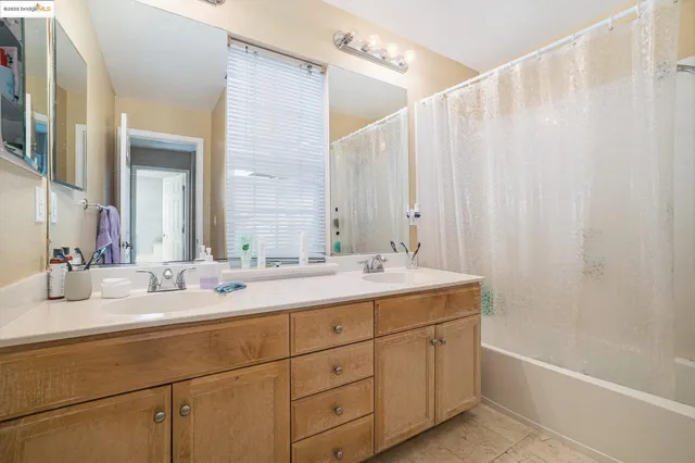 a bathroom with a double vanity sink a mirror and a bathtub