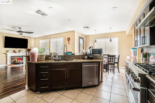 a kitchen with stainless steel appliances kitchen island granite countertop a stove and a sink