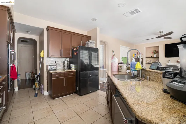 a kitchen with stainless steel appliances granite countertop a refrigerator stove and sink