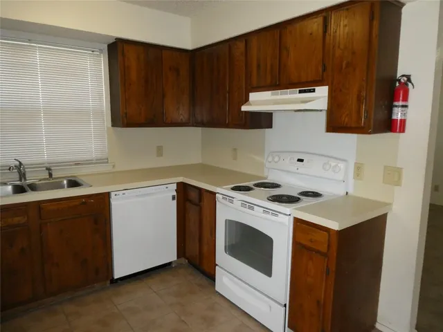a kitchen with a stove sink and cabinets