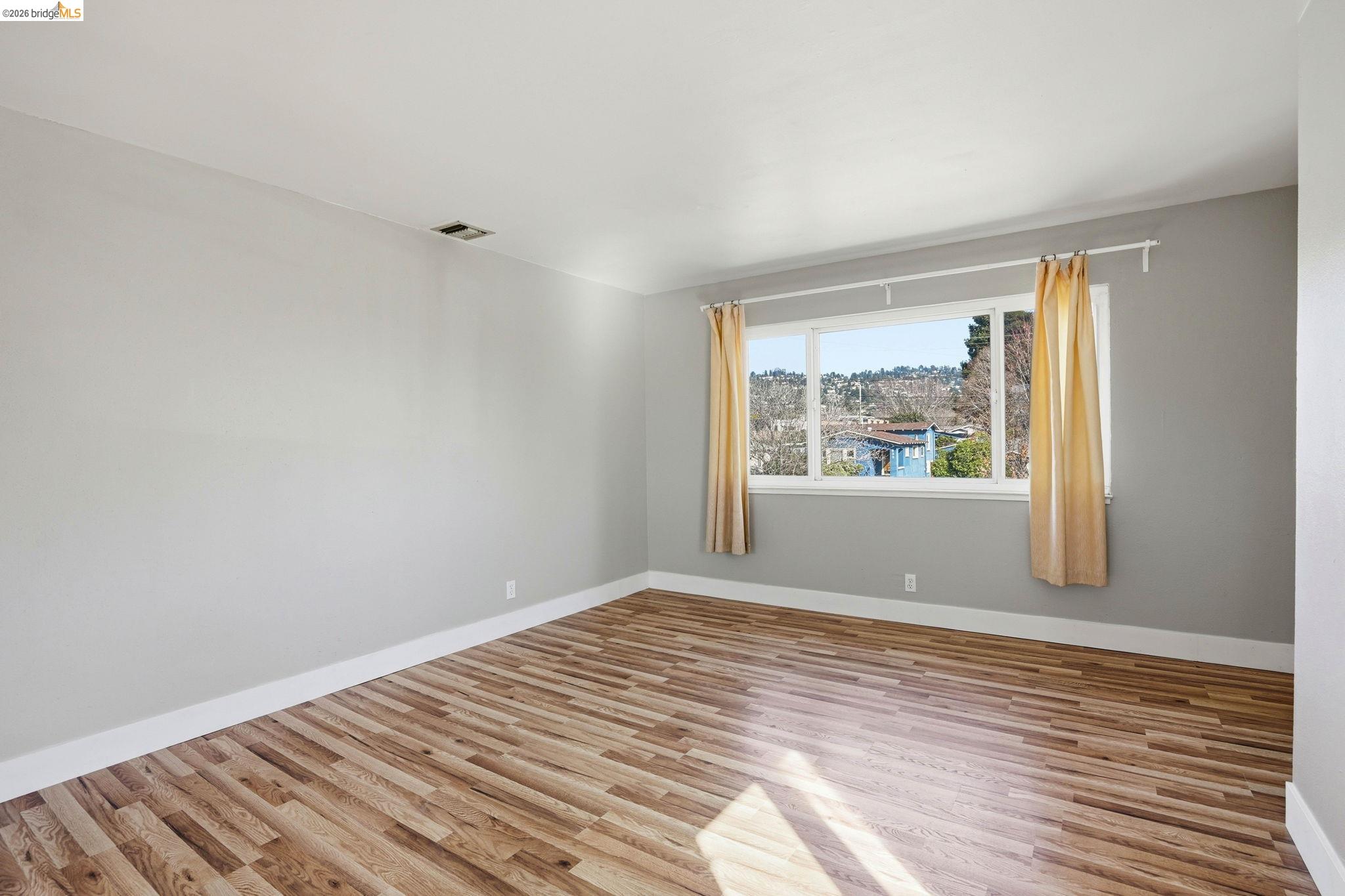 840 Key Rte Boulevard Albany, CA 94706 - Photo 19 of 42 a view of an empty room with wooden floor and a window
