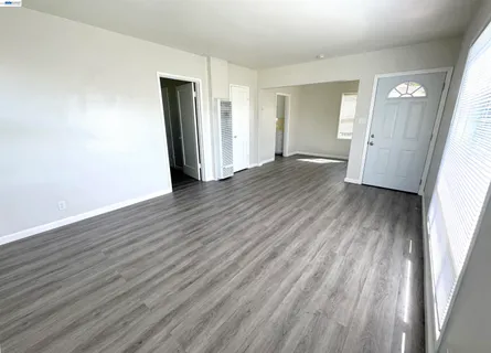 an empty room with wooden floor and closet