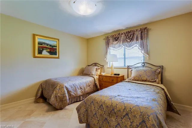 a bedroom with two beds and a painting on the wall