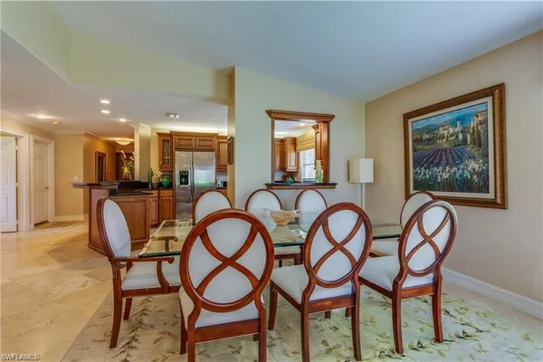 a dining room with furniture and kitchen view