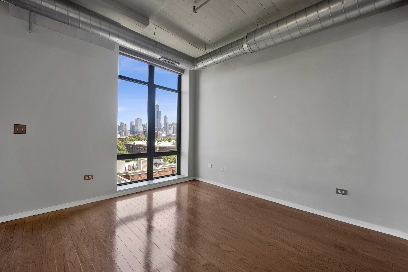 1525 South Sangamon Street, Unit 504 Chicago, IL 60608 - Photo 19 of 32 a view of an empty room with wooden floor and a window