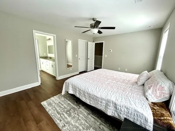 a bedroom with a large bed chandelier and a window