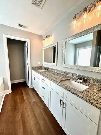 a bathroom with a granite countertop sink and a mirror