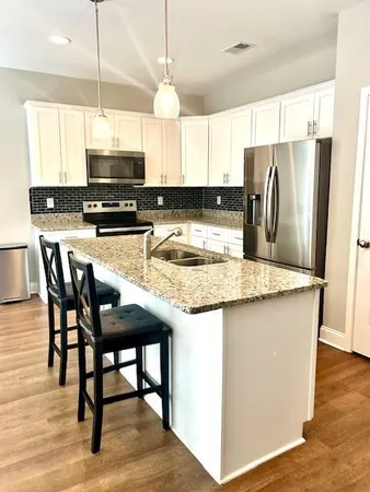 a kitchen with stainless steel appliances granite countertop a stove a sink a microwave and a refrigerator