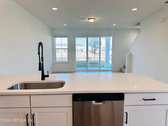 a view of a kitchen with a sink and large window
