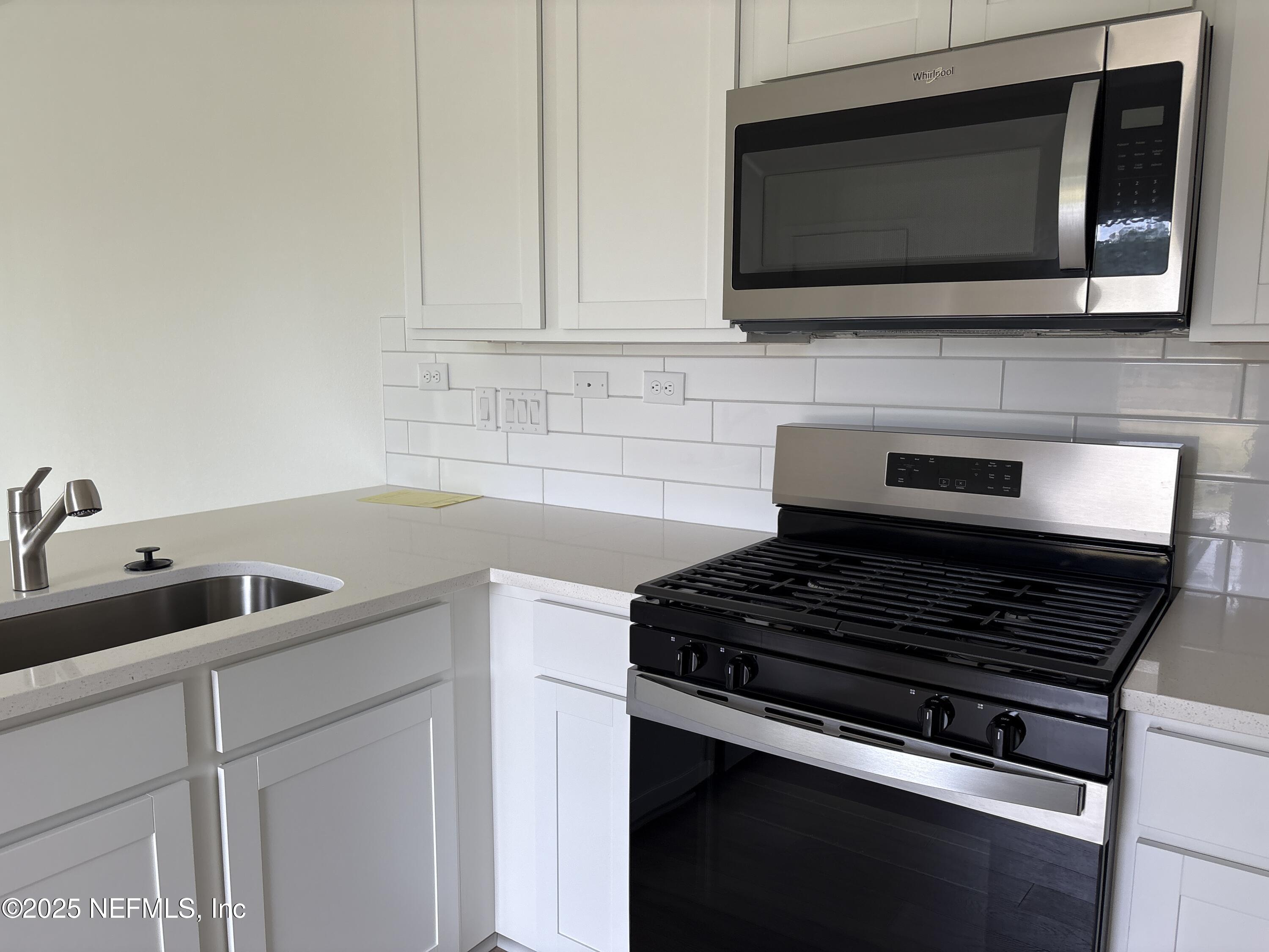 173 Wood Breeze Way St. Augustine, FL 32092 - Photo 4 of 36 a kitchen with microwave and stove