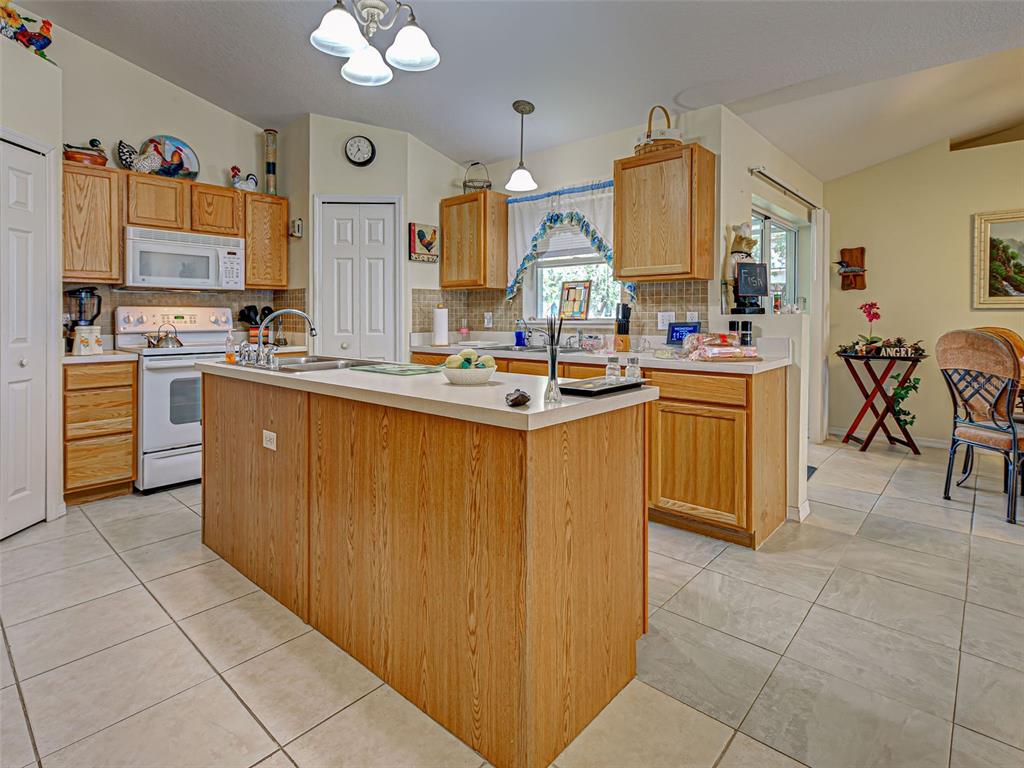 3139 Point Street North Port, FL 34286 - Photo 19 of 58 a kitchen with a sink a counter top space appliances and cabinets