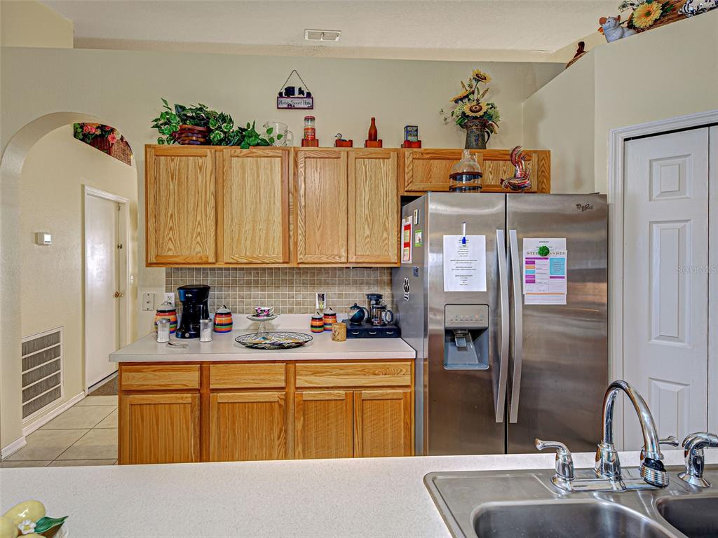 3139 Point Street North Port, FL 34286 - Photo 23 of 58 a kitchen with sink refrigerator and cabinets