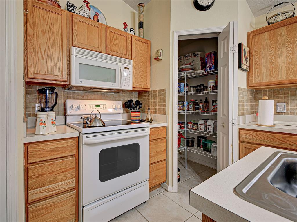 3139 Point Street North Port, FL 34286 - Photo 25 of 58 a kitchen with stainless steel appliances a stove a microwave and cabinets