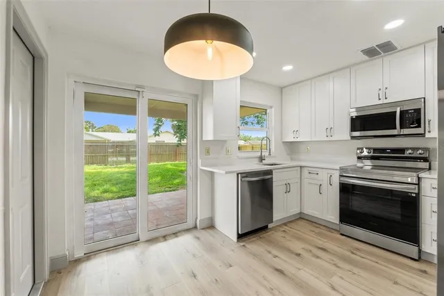 a kitchen with a stove a sink and a microwave