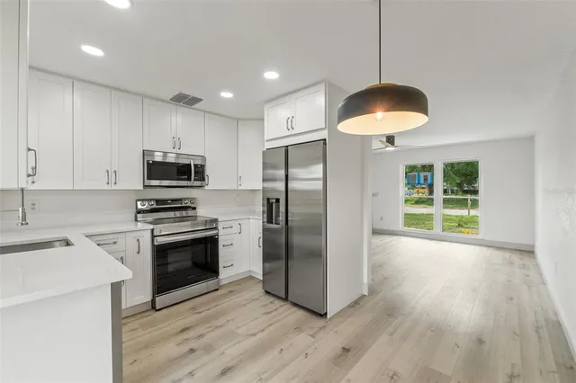 a kitchen with stainless steel appliances a stove a refrigerator and microwave