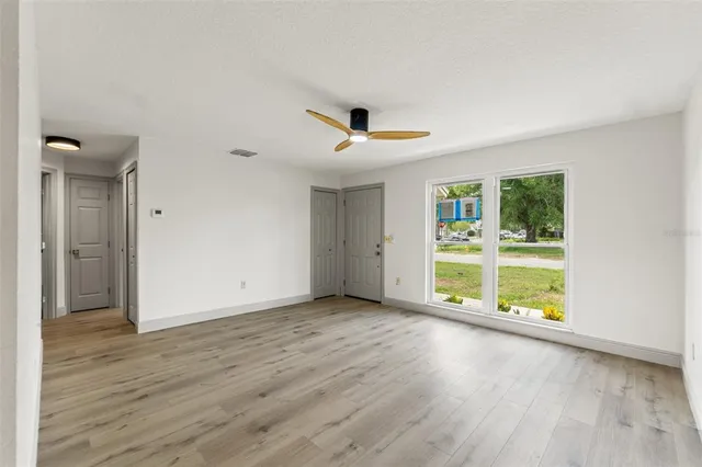 an empty room with wooden floor and windows
