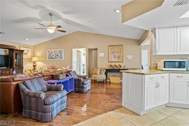 a living room with furniture a chandelier and a view of kitchen