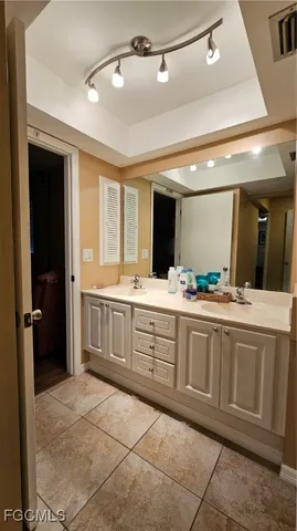 a bathroom with a sink vanity and mirror